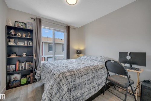 Recessed lighting, wood-finish flooring, and a built-in shelving unit - #4 9250 156 Av Nw, Edmonton, AB - Indoor Photo Showing Bedroom