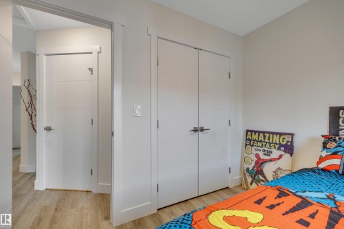Light-toned wood-finish flooring, white paneled doors, and white trim throughout - #4 9250 156 Av Nw, Edmonton, AB - Indoor Photo Showing Bedroom