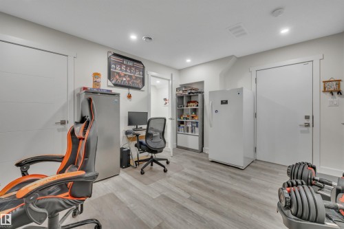 Recessed lighting, wood-finish flooring, and white interior doors - #4 9250 156 Av Nw, Edmonton, AB - Indoor Photo Showing Gym Room