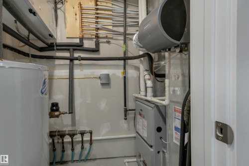 Utility area with a water heater, furnace, and exposed copper piping - #4 9250 156 Av Nw, Edmonton, AB - Indoor Photo Showing Basement