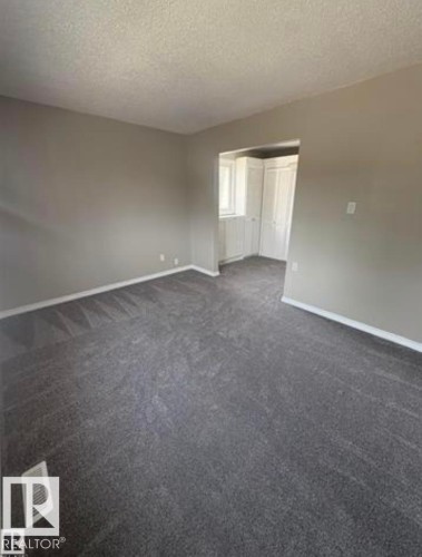 Spacious interior room with gray wall paint and dark gray carpet flooring - 11 Greenfield Estates, St. Albert, AB - Indoor Photo Showing Other Room