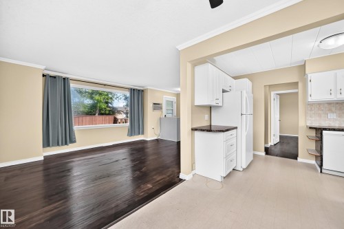 Living area with wood-finish flooring and a wide window - 50 Rocque, Fort Saskatchewan, AB - Indoor Photo Showing Kitchen