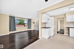 Living area with wood-finish flooring and a wide window - 