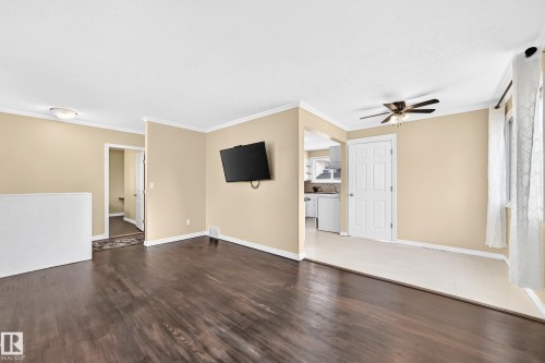 Dark wood-finish flooring, light tone wall paint, white trim, and a ceiling fan - 50 Rocque, Fort Saskatchewan, AB - Indoor Photo Showing Other Room