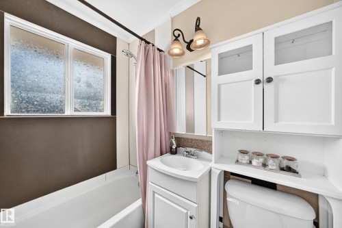 White vanity with integrated sink, overhead wall-mounted lighting, and built-in storage cabinetry - 50 Rocque, Fort Saskatchewan, AB - Indoor Photo Showing Bathroom
