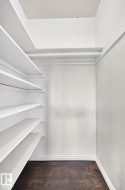 Built-in shelving, dark wood-finish flooring, and white painted walls - 