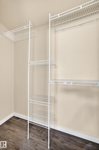Wire shelving system with a hanging rod and wood-finish flooring - 50 Rocque, Fort Saskatchewan, AB - Indoor With Storage