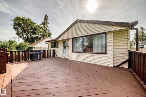 Expansive wood-finish deck with geometric plank pattern, perimeter railing, and direct exterior access - 50 Rocque, Fort Saskatchewan, AB - Outdoor With Exterior