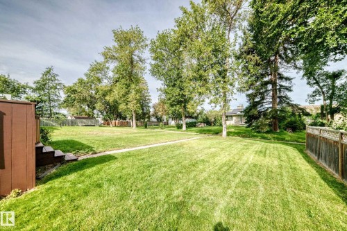 Expansive backyard featuring a lush lawn, mature trees, and a privacy fence - 50 Rocque, Fort Saskatchewan, AB - Outdoor