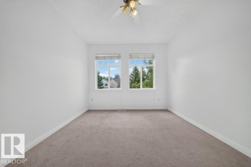Neutral carpeted flooring, white painted walls, and a ceiling-mounted light fixture with fan - #47 30 Levasseur Rd, St. Albert, AB - Indoor Photo Showing Other Room
