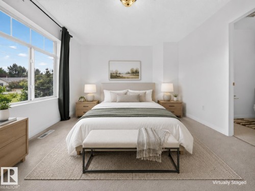Expansive window framing outdoor scenery, carpeted flooring, white walls, and a built-in light fixture - #47 30 Levasseur Rd, St. Albert, AB - Indoor Photo Showing Bedroom