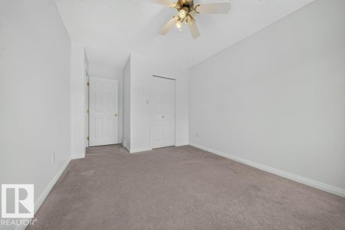 Carpeted flooring, white walls, ceiling fan, and bi-fold closet doors - #47 30 Levasseur Rd, St. Albert, AB - Indoor Photo Showing Other Room