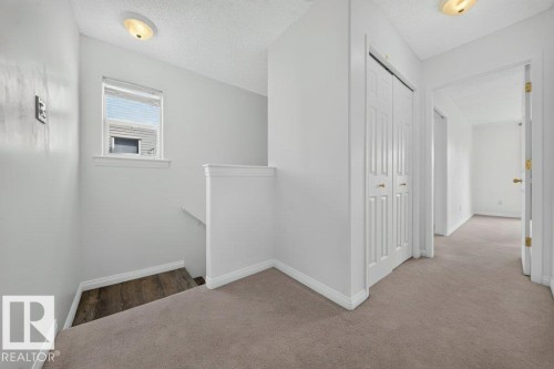 Bright upper-level hallway featuring neutral carpeting, white painted walls, and recessed ceiling lighting - #47 30 Levasseur Rd, St. Albert, AB - Indoor Photo Showing Other Room