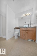 Wood-finish vanity with dual-door cabinetry, a full-width mirror, and overhead vanity lighting - 