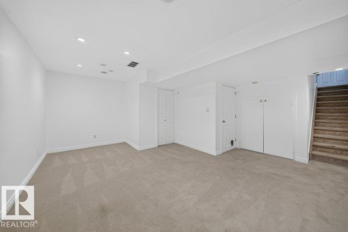 Spacious room featuring neutral carpeting, recessed ceiling lighting, and multiple white panel doors - #47 30 Levasseur Rd, St. Albert, AB - Indoor Photo Showing Other Room