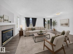 Living area featuring wood-finish flooring, a tiled fireplace, and white walls - 