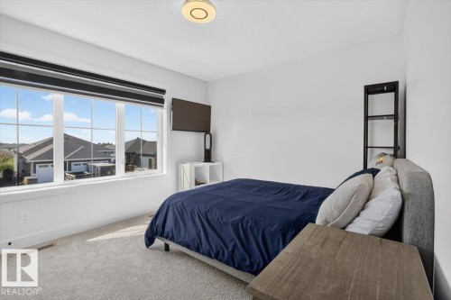 Recessed lighting, large multi-pane window, wall-mounted television, and carpeted flooring - 94 Harvest Crescent, Ardrossan, AB - Indoor Photo Showing Bedroom