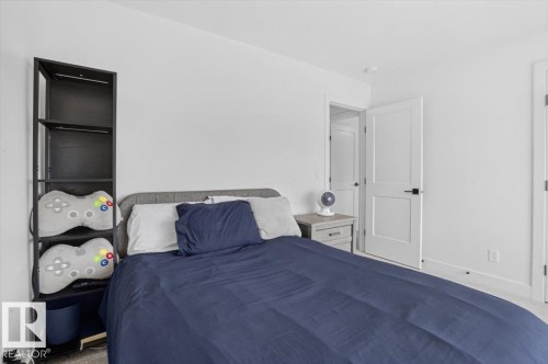 White walls, light gray carpet, and a white paneled door with a black handle - 94 Harvest Crescent, Ardrossan, AB - Indoor Photo Showing Bedroom