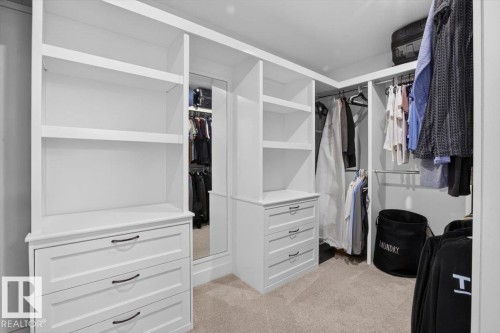 Custom built-in white cabinetry featuring multiple drawers, integrated shelving, and dark hardware - 94 Harvest Crescent, Ardrossan, AB - Indoor With Storage