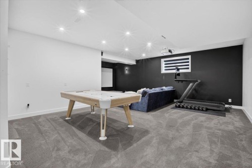 Carpeted lower level with recessed lighting, a white painted wall, and a dark accent wall - 94 Harvest Crescent, Ardrossan, AB - Indoor