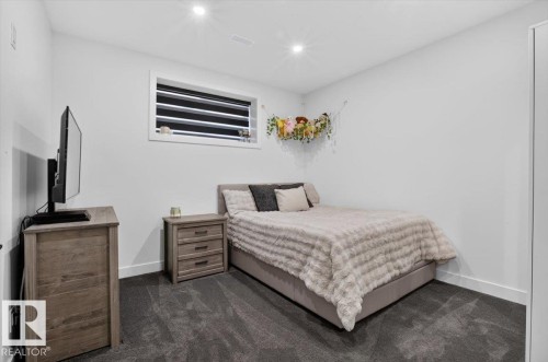 Recessed ceiling lighting, window with horizontal blinds, neutral wall tones, dark carpeting, and white baseboards - 94 Harvest Crescent, Ardrossan, AB - Indoor Photo Showing Bedroom