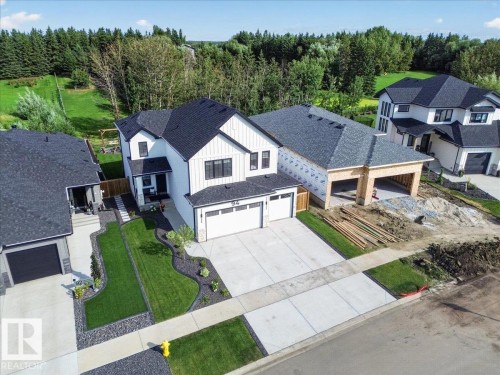 Modern exterior with white vertical siding and black trim accents - 94 Harvest Crescent, Ardrossan, AB - Outdoor With Deck Patio Veranda With Facade