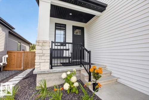 White horizontal siding with stone veneer accents - 94 Harvest Crescent, Ardrossan, AB - Outdoor With Deck Patio Veranda With Exterior
