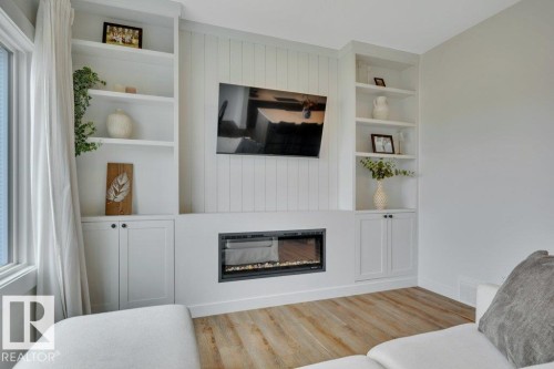 Electric fireplace, TV and wall mount included - 5329 Lark Landing Nw, Edmonton, AB - Indoor Photo Showing Living Room With Fireplace