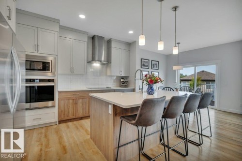With large island and eating bar - 5329 Lark Landing Nw, Edmonton, AB - Indoor Photo Showing Kitchen With Upgraded Kitchen