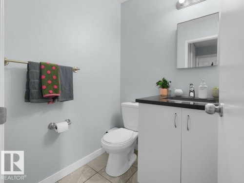 Vanity with dark countertop, integrated sink, and chrome faucet - #54 2131 Oak St, Sherwood Park, AB - Indoor Photo Showing Bathroom