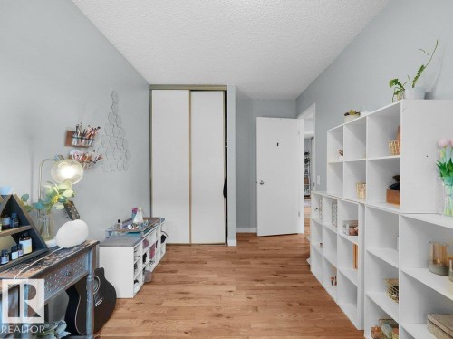 Wood-finish flooring, sliding closet doors, and light gray wall paint - #54 2131 Oak St, Sherwood Park, AB - Indoor