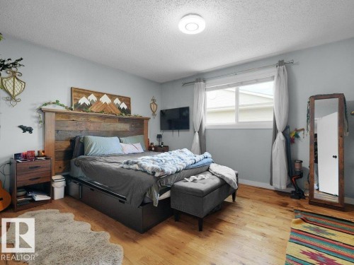 Hardwood-style flooring throughout, light gray wall finishes, and a single window with white trim - #54 2131 Oak St, Sherwood Park, AB - Indoor Photo Showing Bedroom