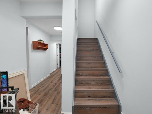 Wood-finish flooring throughout the hallway and stairs - #54 2131 Oak St, Sherwood Park, AB - Indoor Photo Showing Other Room