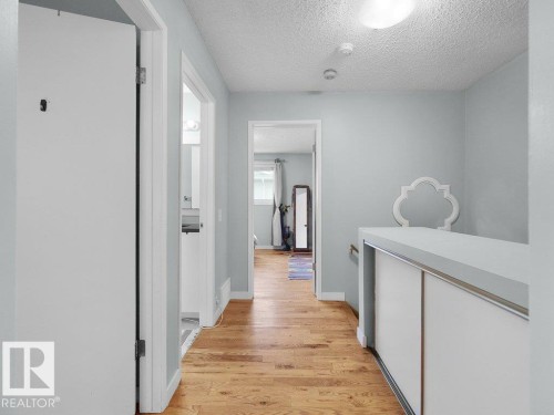Hardwood-style flooring throughout, light blue wall paint, and white trim - #54 2131 Oak St, Sherwood Park, AB - Indoor Photo Showing Other Room