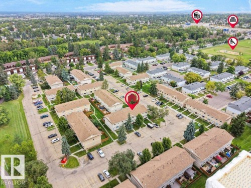 Townhome community with established landscaping and paved parking areas, surrounded by green spaces and residential neighborhoods - #54 2131 Oak St, Sherwood Park, AB - Outdoor With View