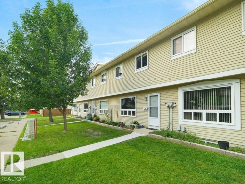 Two-story exterior with horizontal siding, multiple windows, and a concrete pathway leading to the entrance - #54 2131 Oak St, Sherwood Park, AB - Outdoor
