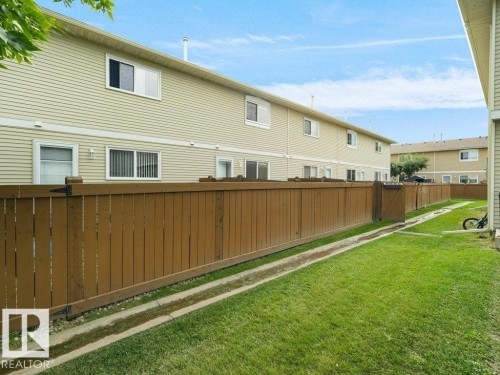 Private fenced backyard with a grassy area and wood fencing - #54 2131 Oak St, Sherwood Park, AB - Outdoor