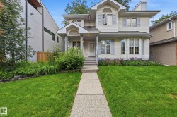Exterior featuring light-colored siding, multiple gabled rooflines, a covered front porch, and a bay window with decorative shutters - 