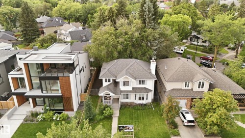 White traditional exterior with a front bay window, gabled roof, and a mature treed lot - 14631 Summit Drive Nw, Edmonton, AB 