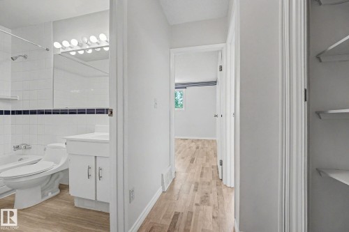 Hallway featuring light wood-finish flooring and a built-in linen closet with shelving - 1096 Knottwood Road Nw, Edmonton, AB - Indoor Photo Showing Bathroom