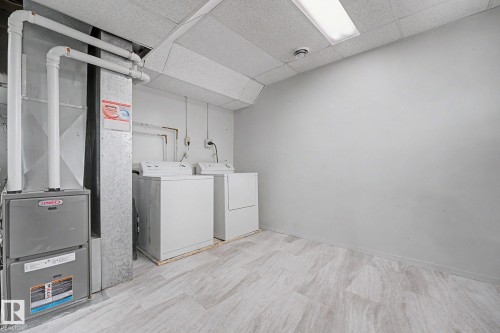 Utility area featuring a furnace system, water heater, and side-by-side washer and dryer units - 1096 Knottwood Road Nw, Edmonton, AB - Indoor Photo Showing Laundry Room