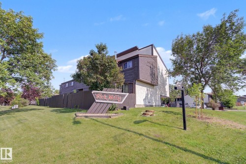 Two-story townhouse exterior with brown horizontal siding and light-colored stucco - 1096 Knottwood Road Nw, Edmonton, AB - Outdoor