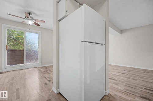 White top-freezer refrigerator positioned within an open floor plan - 1096 Knottwood Road Nw, Edmonton, AB - Indoor Photo Showing Other Room