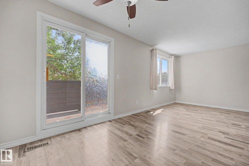Spacious room featuring wood-finish flooring and light-toned walls - 1096 Knottwood Road Nw, Edmonton, AB - Indoor Photo Showing Other Room
