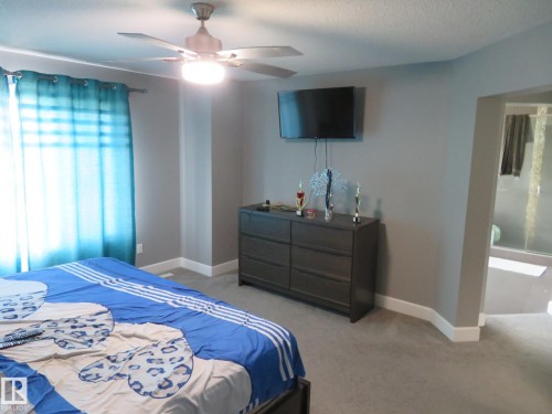 Recessed ceiling fan with integrated lighting, wall-mounted television, and carpeted flooring - 3233 Winspear Crescent Sw, Edmonton, AB - Indoor Photo Showing Bedroom