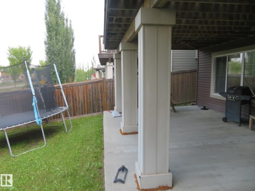 Concrete patio with structural support columns and a privacy fence - 3233 Winspear Crescent Sw, Edmonton, AB - Outdoor With Exterior
