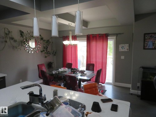 Tray ceiling design with recessed lighting, pendant lighting fixtures, and a glass sliding door - 3233 Winspear Crescent Sw, Edmonton, AB - Indoor