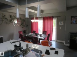 Tray ceiling design with recessed lighting, pendant lighting fixtures, and a glass sliding door - 