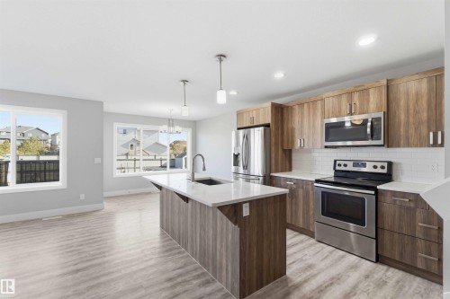 Kitchen island with undermount sink and gooseneck faucet - 7 Mclean Court, Leduc, AB - Indoor Photo Showing Kitchen With Stainless Steel Kitchen With Upgraded Kitchen