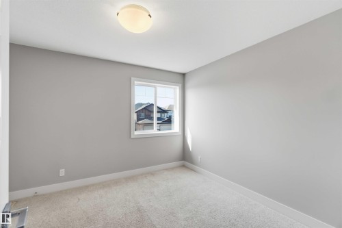 Neutral wall color, carpeted flooring, window with white trim, and ceiling-mounted light fixture - 7 Mclean Court, Leduc, AB - Indoor Photo Showing Other Room